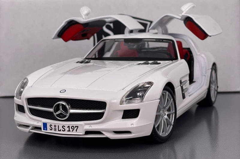 White Mercedes-Benz car with open gull-wing doors on a gray background